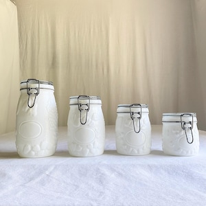 Juego de 4 botes vintage de vidrio blanco para leche, con diseño de frutas en relieve Wheaton, tapa con abrazadera, decoración de cocina estilo cabaña francesa.