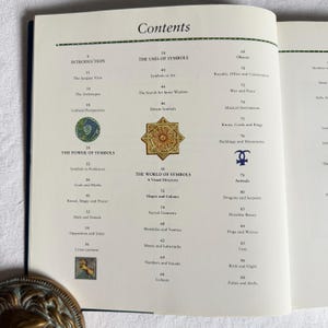 May include: An open book displaying a contents page. The title reads "Contents" with sections on symbols, including "The Power of Symbols" and "The World of Symbols". Decorative illustrations are visible throughout the page.