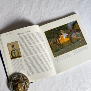 May include: An open book displaying the title "Male and Female". The right-hand page shows a vibrant illustration of two figures in a garden setting. A brass lion head ornament is positioned at the bottom of the left page.