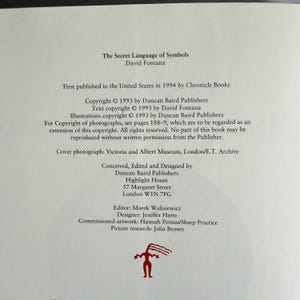 May include: A page from "The Secret Language of Symbols" by David Fontana, published in 1994. The text includes copyright information, publisher details, and credits for the cover photograph, design, and artwork. A red graphic is at the bottom.
