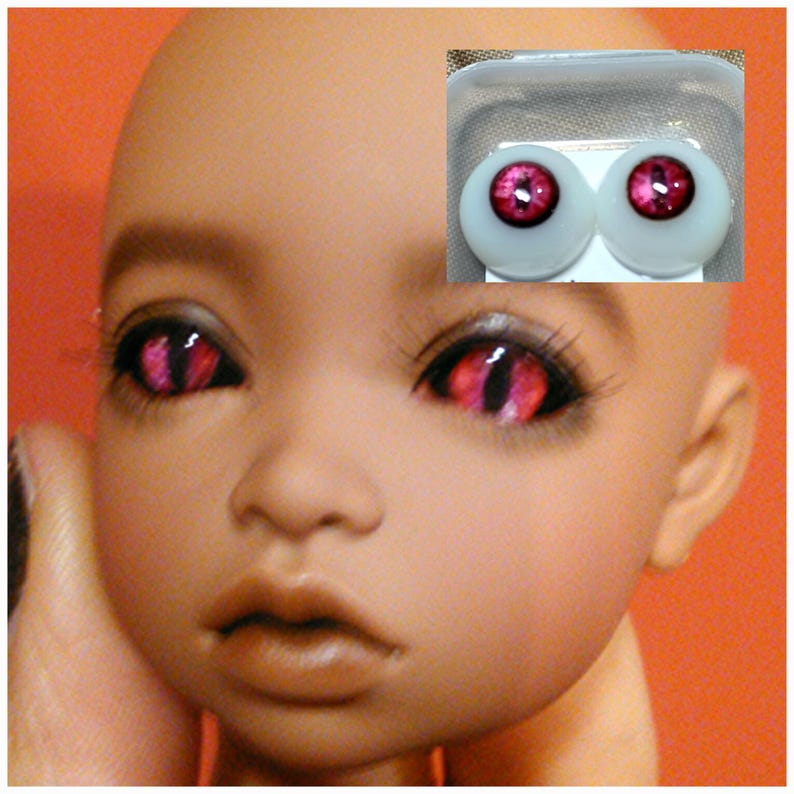 Puede incluir: Una mu&ntilde;eca con ojos rosas y negros. La mu&ntilde;eca tiene una tez marr&oacute;n claro y lleva un par de ojos rosas y negros.