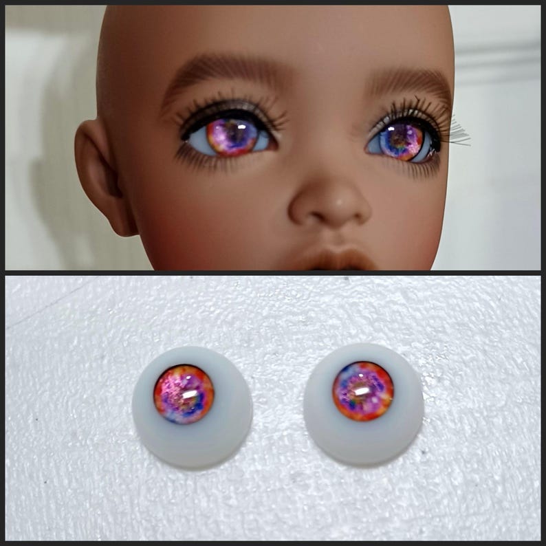 May include: A pair of pink and purple doll eyes with a galaxy design. The eyes are on a white background.