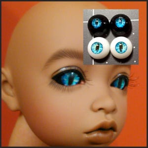 Puede incluir: Un par de ojos de mu&ntilde;eca azules y blancos con un dise&ntilde;o de ojo de gato negro. Los ojos se muestran sobre un fondo blanco con un borde negro.