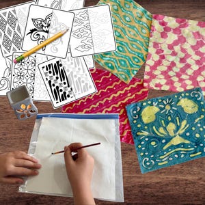 Puede incluir: Un conjunto de materiales de arte y manualidades, que incluyen tarjetas para colorear con varios patrones, cuadrados de tela coloridos, un pequeño quemador de aceite de cerámica y un pincel. Una persona está pintando sobre papel dentro de una bolsa de plástico.