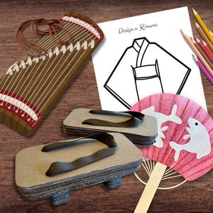 May include: A set of Japanese cultural items including a wooden koto, a pair of geta sandals, a pink hand fan with a fish design, and a coloring page with the text "Design a Kimono".