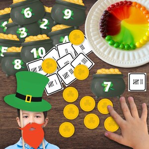 以下が含まれることがあります： 聖パトリックの日のテーマにした教育ゲーム。2～10の数字が書かれた緑色の金の鍋、金貨、集計カードがあります。緑色のレプラコーンハットと赤いひげの小道具も含まれています。カラフルなキャンディーの皿が背景にあります。