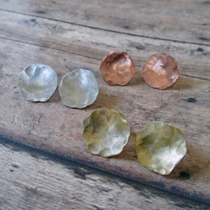 May include: Four pairs of hammered metal earrings in silver, copper, and brass.