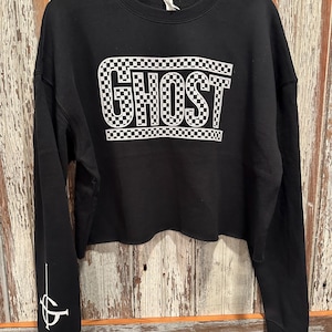 May include: Black cropped sweatshirt with a white checkered "GHOST" graphic on the front and a white "GHOST" symbol on the left sleeve.