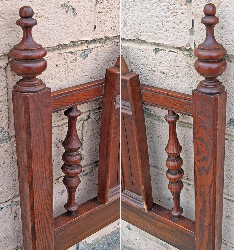 Pu&ograve; includere: Primo piano di una testiera di letto in legno vintage. La testiera &egrave; realizzata in legno marrone scuro con fusi e pinnacoli torniti e ornati. La cornice ha un design classico e antico, che mostra le venature del legno e l'artigianato. La testiera &egrave; contro un muro strutturato di colore chiaro.