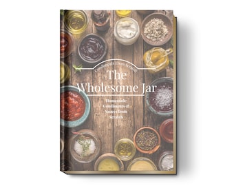 May include: A cookbook titled "The Wholesome Jar" featuring a wooden background with various bowls of homemade condiments and sauces. The cover text reads "Homemade Condiments & Sauces From Scratch".