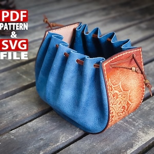 May include: A handmade leather pouch with a drawstring closure. The pouch features a blue suede exterior and a brown leather accent with an embossed floral design. The text "PDF PATTERN & SVG FILE" is visible in the upper left corner.
