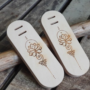May include: Two wooden tags with a burned-in design of a lotus flower and a mandala. The tags have two holes at the top.