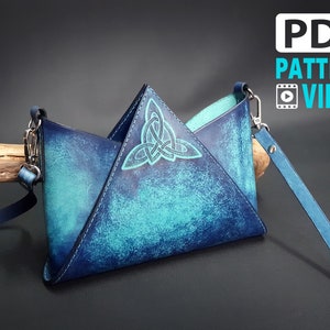 May include: A blue leather crossbody bag with a Celtic knot design. The bag has a triangular shape and a long strap.