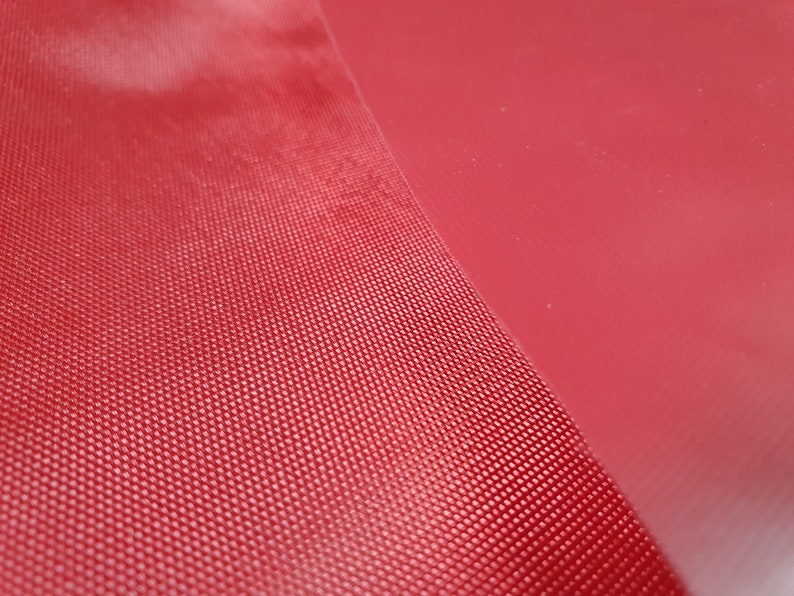 Pode incluir: Close-up de um tecido vermelho texturizado com uma superf&iacute;cie lisa vermelha ao lado.