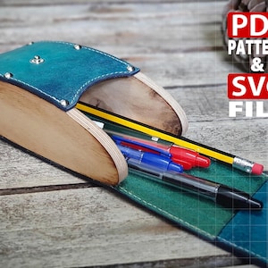 May include: A pencil case made of light-colored plywood and teal leather, secured with metal rivets. The case holds a yellow pencil, a red pen, a blue pen, and a black pen. Text on the image reads: PDF PATTERN & SVG FILE.