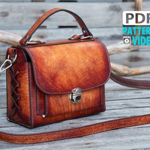 May include: A structured brown leather handbag with a burnished finish, featuring a top handle, a detachable shoulder strap, a front flap with a silver metal push-lock closure, and side panels with decorative leather lacing. Text reads PDF PATTERN VIDEO.