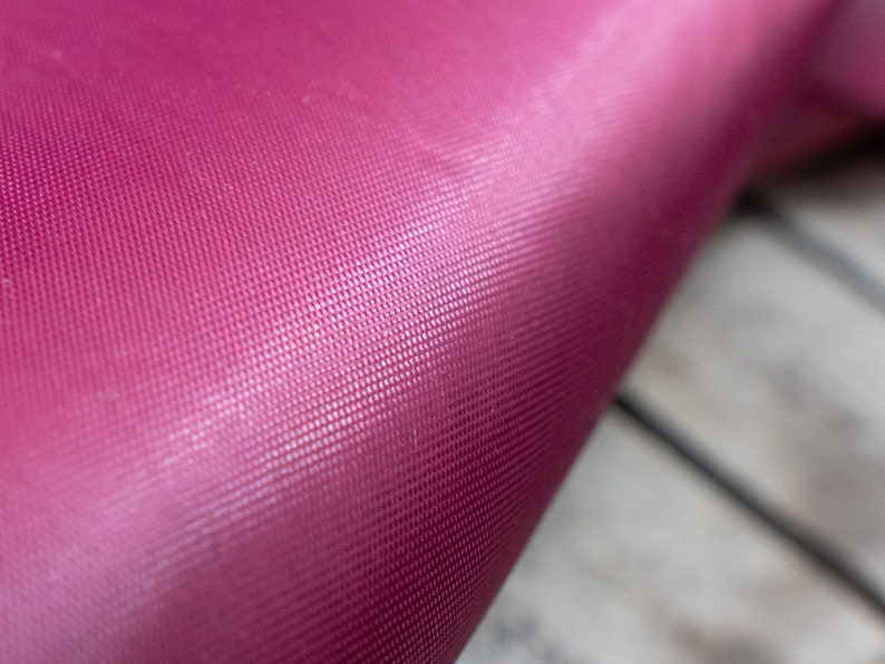 Pode incluir: Close-up de um tapete de ioga rosa escuro com uma superf&iacute;cie texturizada.