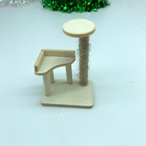 May include: A small wooden cat tree with a round platform and a scratching post covered in sisal rope.