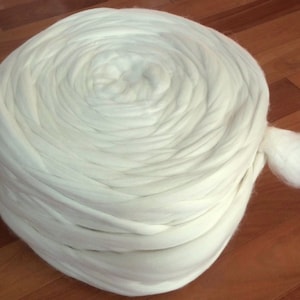 May include: A large roll of white wool roving, perfect for spinning or felting.