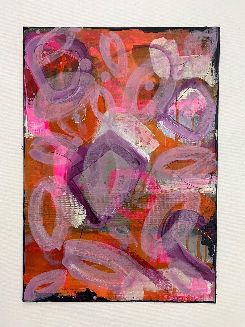 May include: Abstract painting with a mix of pink, purple, orange, and white paint. The painting has a textured surface and a black background.