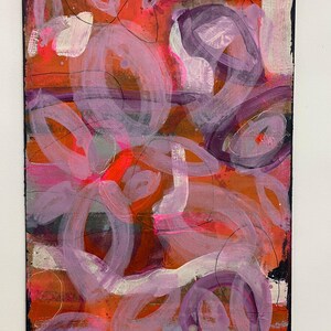 May include: Abstract painting with a red, orange, and purple color scheme. The painting features a variety of shapes and lines, including circles, ovals, and swirls.