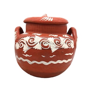 May include: A terracotta-colored ceramic pot with a lid. The pot features white painted floral and wave designs. It has two handles and a small knob on the lid. The pot is likely used for storage or decoration.