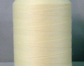 May include: A spool of off-white thread on a white plastic bobbin.