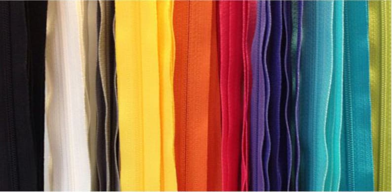 May include: A variety of zipper tapes in different colors, including black, white, beige, yellow, orange, red, purple, blue, turquoise, and green.