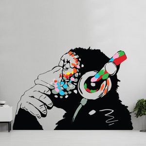May include: A black and white illustration of a monkey wearing headphones with colorful accents. The monkey is listening to music and has a thoughtful expression on its face.
