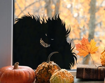 May include: A black silhouette of a monster with sharp teeth peering through a window.  The windowsill is decorated with gourds, pumpkins, and a single orange maple leaf.