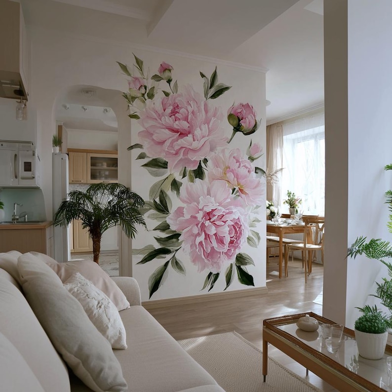 Peut inclure: Une grande peinture murale repr&eacute;sentant des pivoines roses avec des feuilles vertes et des bourgeons. La d&eacute;coration florale est peinte sur un mur blanc, ajoutant une touche de nature &agrave; l'int&eacute;rieur. La pi&egrave;ce comprend un canap&eacute;, une table et une petite plante.