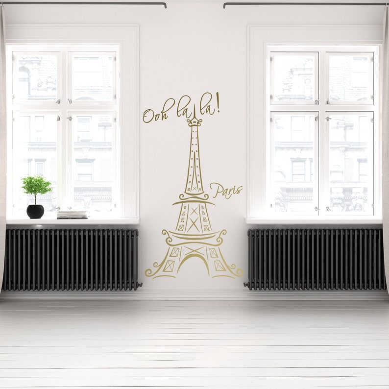 May include: A gold Eiffel Tower wall decal with the text "Ooh la la! Paris" on a white wall.