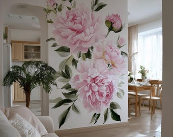 May include: A large wall mural featuring a cluster of pink peony flowers with green leaves. The flowers are painted in a realistic style, with soft shading and delicate details. The mural is on a white wall in a living room setting.