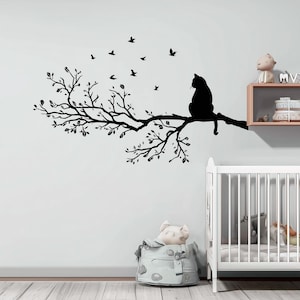 Könnte beinhalten: Ein schwarzer Wandaufkleber mit einer Silhouette einer Katze auf einem Ast mit Blättern und fliegenden Vögeln. Diese Wanddekoration ist für die Inneneinrichtung konzipiert und fügt eine natürliche Note hinzu.