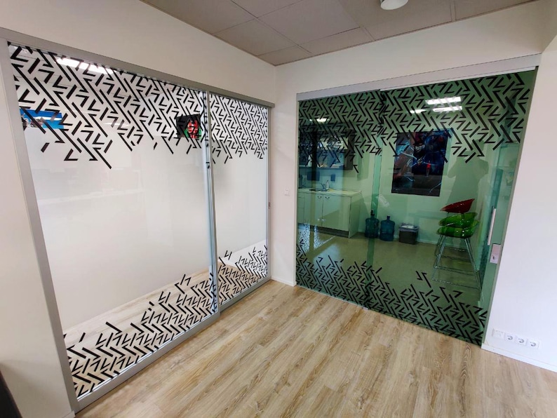 Puede incluir: Dos puertas correderas de vidrio con un patr&oacute;n geom&eacute;trico en blanco y negro. Las puertas est&aacute;n en una habitaci&oacute;n con pisos de madera clara.