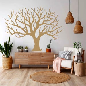 May include: A large, tan tree decal adorns a white wall, creating a focal point in a living room setting. The room features a wooden cabinet, a white armchair with a striped pillow, and a jute rug, creating a natural, earthy aesthetic.