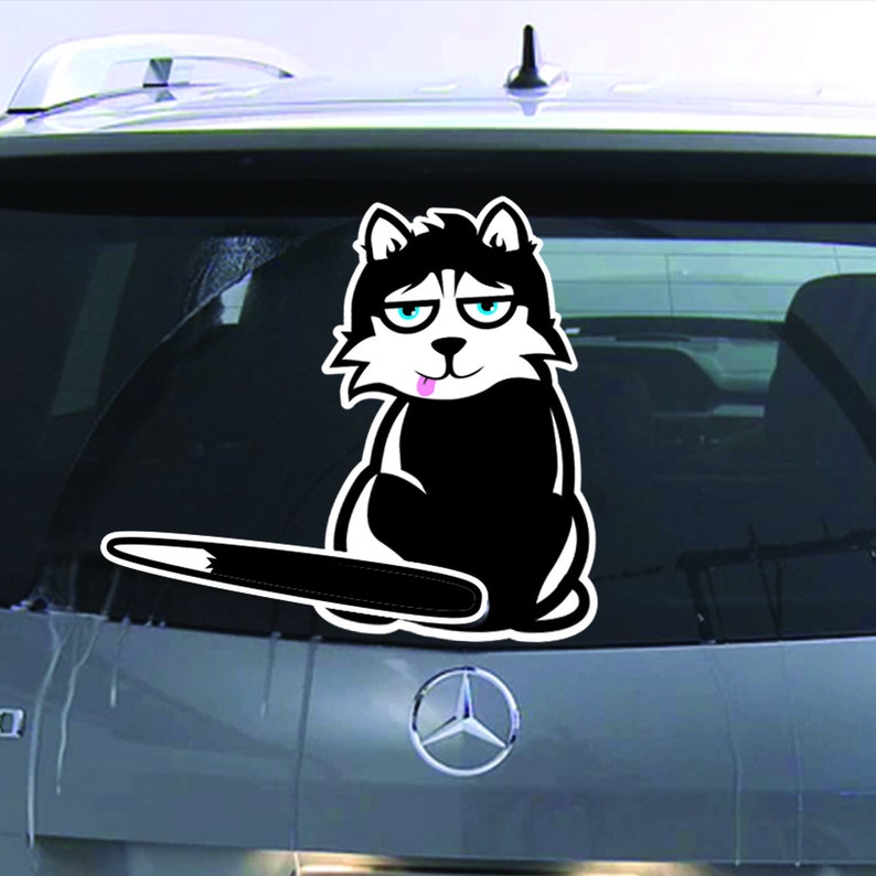 May include: A black and white cartoon husky dog sticker with a pink tongue sticking out. The dog is sitting on its hind legs with its tail sticking out behind it. The sticker is on the back window of a car.