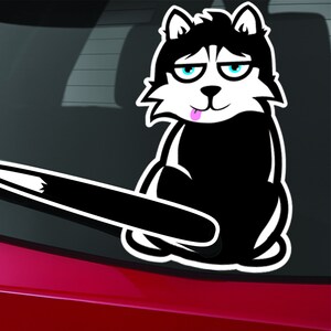 May include: Black and white cartoon husky dog sticker with a pink tongue sticking out. The dog is sitting with its tail sticking out behind it.