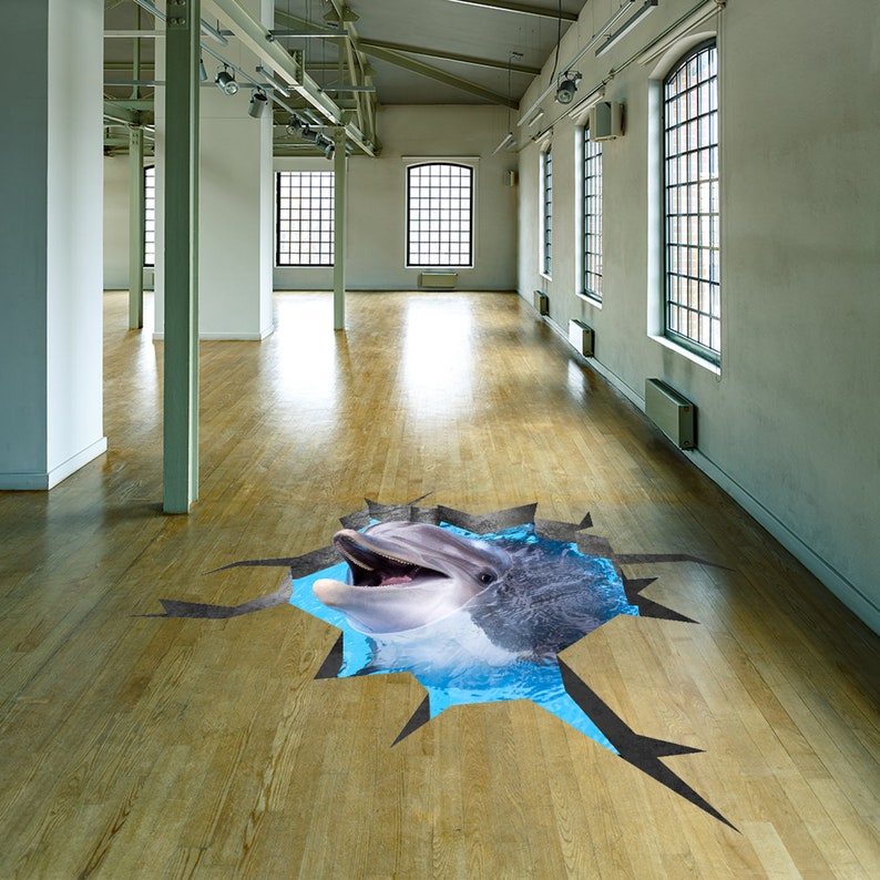 May include: A 3D floor decal of a dolphin jumping out of a cracked wooden floor. The dolphin is gray and white with a blue water background.