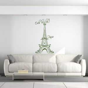 May include: A white couch with a green Eiffel Tower wall decal that says "Ooh la la! Paris".