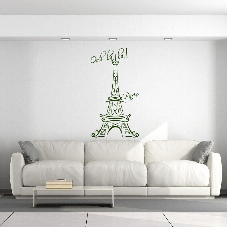 May include: A white couch with a green Eiffel Tower wall decal that says "Ooh la la! Paris".