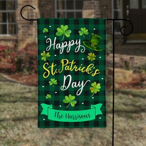 May include: Green and black checkered garden flag with a shamrock design and the text "Happy St. Patrick's Day" and "The Harrisons".