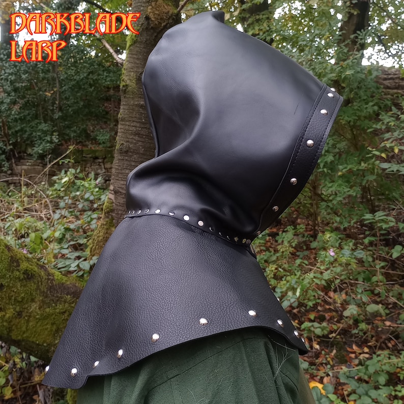May include: Black leather hooded cowl with silver studs. The cowl has a pointed hood and a wide collar.
