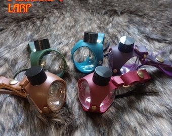 Pequeñas botellas de pociones de plástico en un portador que puedes desenganchar de tu cinturón, el Chemisphere mini.