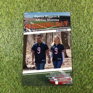 May include: A rectangular wedding program featuring a top image of a football stadium, the text Deena Riggers & Adrian Morena WEDDING DAY PROGRAM, a center photo of two people in navy blue jerseys with the number 9, and a bottom football graphic.