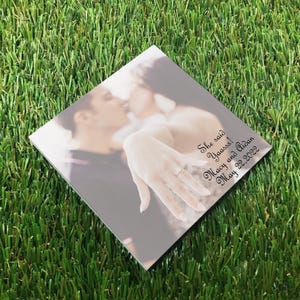 Custom save the date Post-it notes featuring a personalized photo and wedding date, shown as a square on a grass background