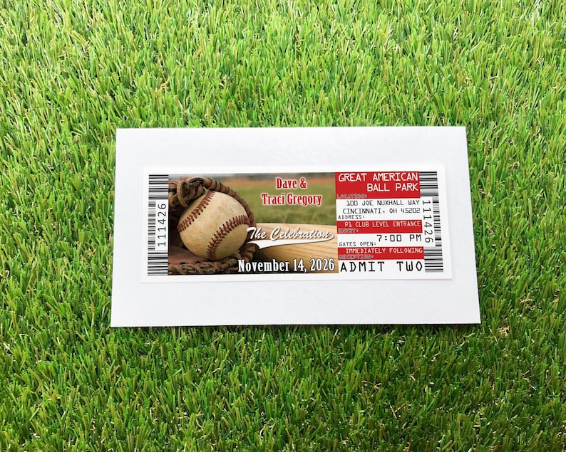 A baseball ticket invitation, over a white envelope over a grass background