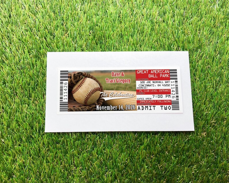 A baseball ticket invitation, over a white envelope over a grass background