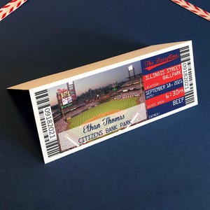 May include: A folded paper card designed as a baseball ticket featuring a photograph of a stadium field. The text reads The Reception, Illinois Street Ballpark, September 18, 2021, 6:30 PM, Beef, Ethan Thomas, and Citizens Bank Park with barcodes.