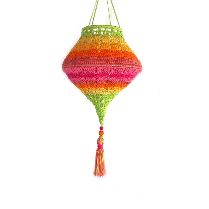 May include: A colorful crocheted hanging lamp with a tassel. The lamp is made in a rainbow of colors, including green, orange, pink, and red. The tassel is made of green, pink, and yellow yarn.